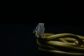 Closeup shot of a yellow ethernet cable isolated on a black background