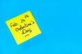 Closeup shot of a yellow romantic Valentine's Day note on a blue surface
