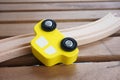 Closeup shot of a yellow wooden toy car lying on a wooden track Royalty Free Stock Photo