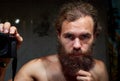 Closeup shot of a young attractive man with blue eyes and a beard holding a camera Royalty Free Stock Photo