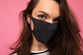 Closeup shot of of young fascinating woman wearing mediacal face mask isolated over background wall. Protection against