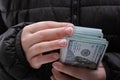 Closeup shot of a young female counting a pack of dollars