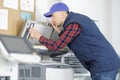 Closeup shot young male technician repairing digital photocopier machine Royalty Free Stock Photo