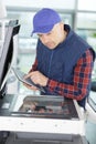 closeup shot young male technician repairing digital photocopier machine Royalty Free Stock Photo