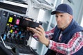 Closeup shot young male technician repairing digital photocopier machine Royalty Free Stock Photo