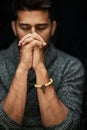 His faith is strong. Closeup shot of a young man praying with his eyes closed. Royalty Free Stock Photo