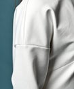 Closeup of shoulder and sleeve of pullover of trendy pantsuit, kimono style, woman wears. Side view