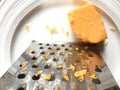 Closeup of shredded cheddar cheese near grater