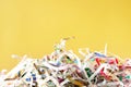 Closeup shredded paper texture and reuse colorful paper scrap of document on yellow paper background. Selective focus image. Royalty Free Stock Photo