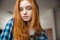 Closeup of shy girl with red hair in checkered shirt Royalty Free Stock Photo