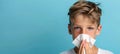 Closeup of sick young boy blowing nose into tissue with empty space for text placement Royalty Free Stock Photo