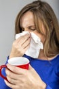 Closeup of sick young woman blowing her nose Royalty Free Stock Photo