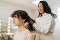 Closeup side view of beautiful woman having hair cut at female hairstylist in beauty studio. Close up face of cute lady Royalty Free Stock Photo