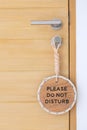 Closeup sign PLEASE DO NOT DISTURB hanging near wooden door at luxury hotel Royalty Free Stock Photo