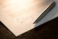 Closeup of signature and silver ballpoint pen with on document. Focus on signature Royalty Free Stock Photo