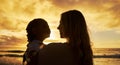Closeup silhouette of mother and daughter standing on the beach at sunset. Backlit young woman and girl child smiling Royalty Free Stock Photo