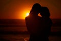 Closeup silhouette of a mother and daughter watching the sunset at the beach . Rear view of of a woman and her little Royalty Free Stock Photo