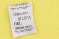 Closeup of a silica packet on yellow textured material