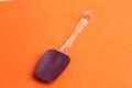 Closeup of a silicone spatula isolated on an orange background