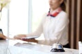 Closeup of silver bell ring on hotel reception service desk with receptionist service customer at hotel counter desk as blurred Royalty Free Stock Photo