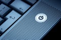 Closeup of silver blue computer laptop selective focus on standby on button ideal for technology business start power energy Royalty Free Stock Photo