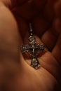 Closeup silver cross in the palm