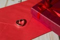 Closeup of a silver heart pendant on a red envelope and gift box Royalty Free Stock Photo