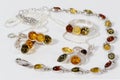 Closeup silver pendant, earrings, ring and bracelet with baltic amber on white acrylic desk. Royalty Free Stock Photo