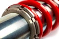 Closeup of a silver and red coil shock absorber other tools in the background Royalty Free Stock Photo
