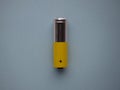 Closeup silver and yellow AA size alkaline batterie isolated on blue background top view