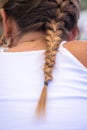 Closeup of a simple French braid of a female with a white blouse