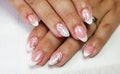 Closeup of a simple white french manicure on oval-shaped nails