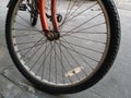 closeup single front wheel of old red bicycle park on concrete street Royalty Free Stock Photo