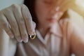 Closeup of a single sad wife after divorce lamenting holding the wedding ring in room at home Royalty Free Stock Photo