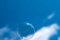 Closeup of a single soap bubble with a cloudy blue sky in the background Royalty Free Stock Photo