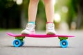 Closeup of skateboarder legs. Kid riding skateboard outdoor.