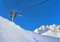 Ski lift in beautiful snowy mountains under blue sky