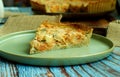 Closeup of a slice of delicious breakfast quiche, placed on a green plate