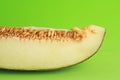 Closeup of a slice of melon isolated on a green background