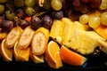 closeup sliced bananas, oranges, pineapples, and grapes Royalty Free Stock Photo