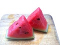 Closeup sliced of watermelon on brown chopping board.