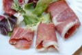 closeup of slices of rolled cured pork ham jamon with lettuce Royalty Free Stock Photo