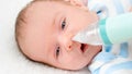 Closeup slow motion of cleaning tiny nose of newborn baby with electric aspirator. Concept of babies and newborn hygiene