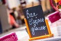 Small black board menu indicating bar, ice-creams and pancakes (Bar Crepes Glaces in French) on a table outside
