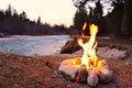 Closeup of a small campfire near a river in a forest in the evening Royalty Free Stock Photo