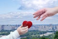 A child hand is giving a knitted heart to a female hand