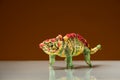 Small colorful figurine of a dinosaur, brown background