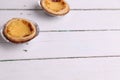 Closeup of small cream cakes on a wooden table under the lights