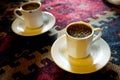 Closeup of a small cups of traditional turkish, menengic coffee on an ethnic table cloth
