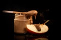 closeup small glass jar with peanut butter next to sliced apple Royalty Free Stock Photo